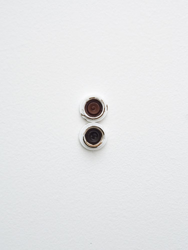 lascaux (unwanted) #2, 2011.  
caps from tubes of artists' acrylic 'reduced to clear' (transoxide brown and oxide brown light) on wall
2cm x 4cm
