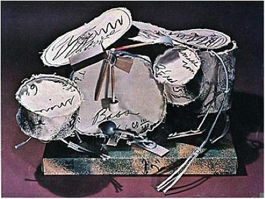 Claes Oldenburg
	<i>Miniature Soft Drum Set</i>
	3-D screenprint and spray paint
	on canvas with rope and wood
	Edition of 200
	11 x 19 x 14 inches
	27.94 x 48.26 x 35.56 cm