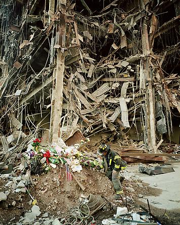 A fireman places flowers at the foot of Building 4