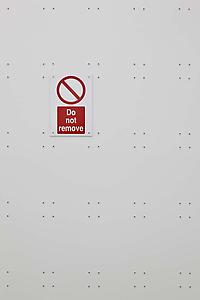 Ceal Floyer, <i>Do Not Remove,</i> 2011, Wall plugs, ready-made "Do not Remove" sign, wall, Variable