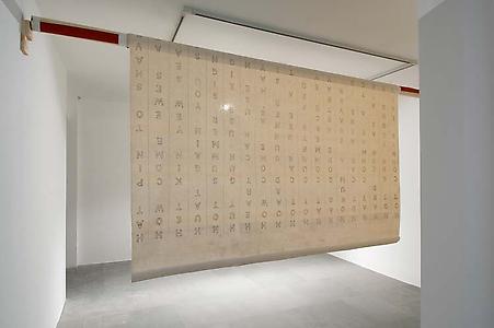 John Latham
<i>THE, </i>1976
Lettering on canvas attached to wooden cylinder
400 cm width, variable length, roller 80 cm diameter