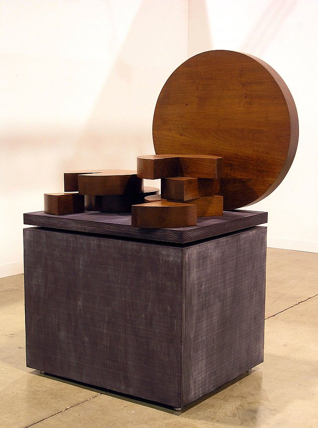 Michael Heizer<br />Thailand<br />1977<br />teak wood sculpture in eight parts on anodyne-dyed plywood base by the artist<br />62 1/2 x 43 1/2 x 32 inches overall<br />largest element is 32 inches in diameter<br />