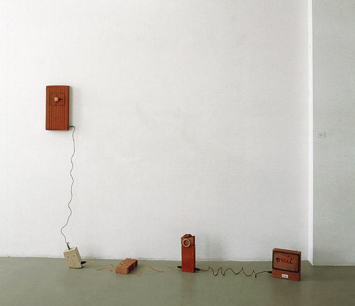 Robert Filliou<br />Western Mandala<br />1980<br />bricks, colored twine, pastel, painted wood, wood,<br />label and electrical plugs<br />26 3/4 x 72 13/16 x 19 5/16 inches<br />(68 x 185 x 49 cm)<br />